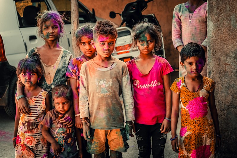 Children with festival colours on their faces standing in a lane